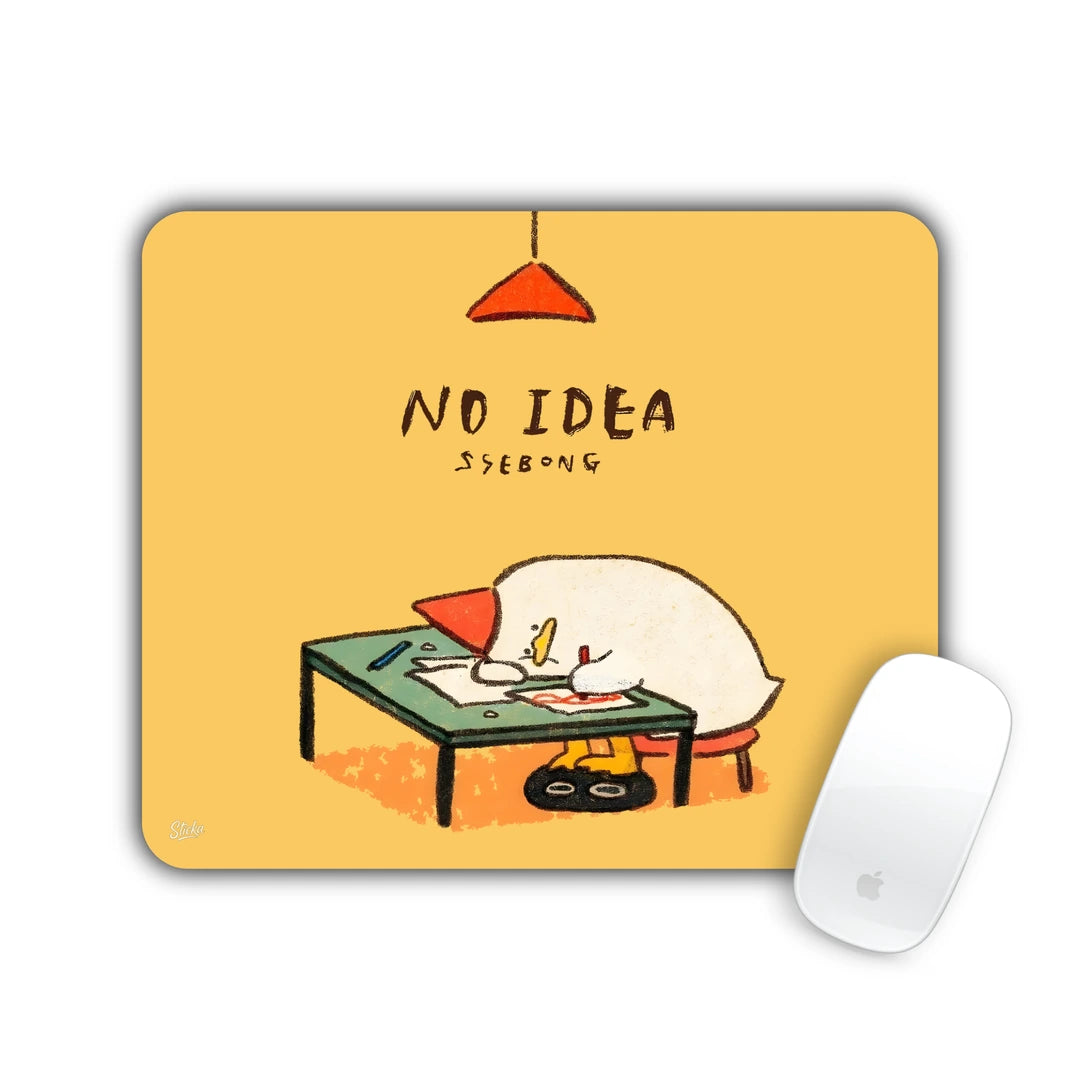 Duck asleep face-down on a little desk under a lamp with 'NO IDEA' text on yellow mouse pad 23x19