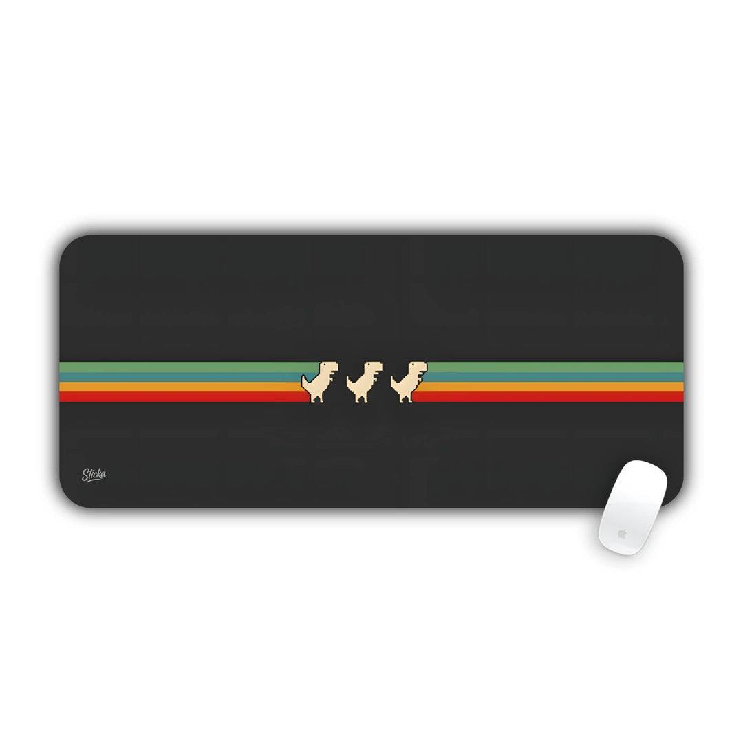 8-bit T-Rex dinosaurs walking across horizontal retro rainbow stripes on dark grey desk pad 70x30