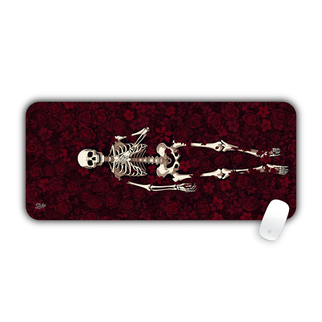 Full anatomical human skeleton reclining across a dark red rose petal background desk pad 70x30