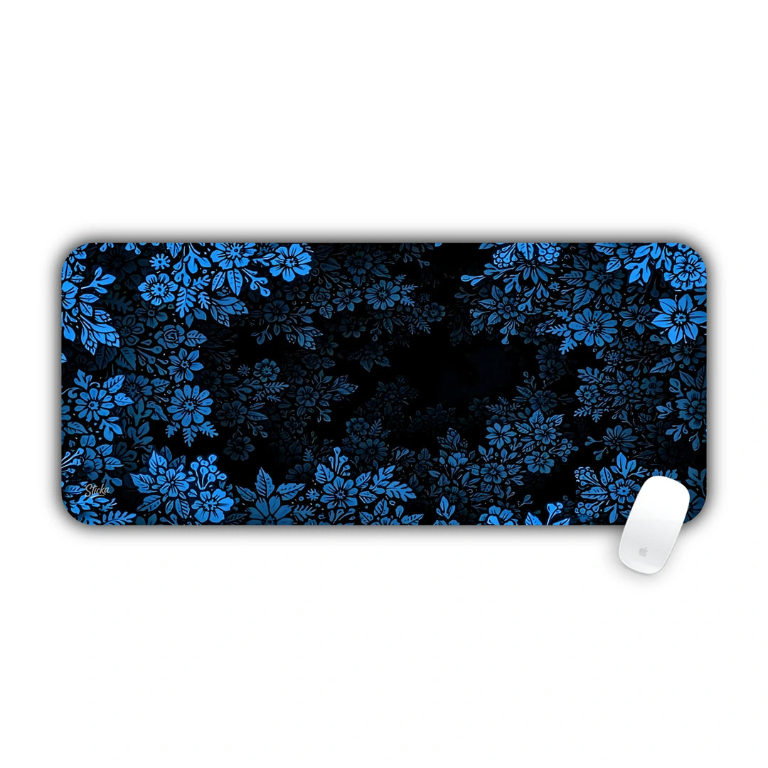 Dense pattern of blue flowers and foliage over a dark midnight background desk pad 70x30